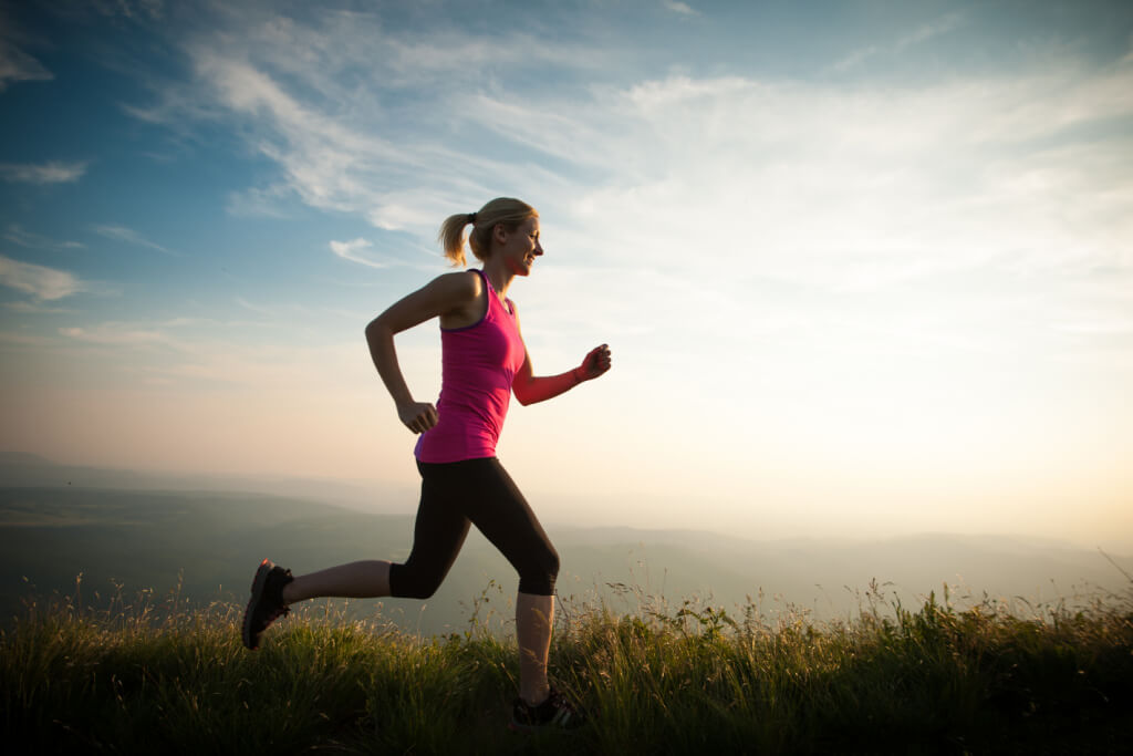 woman running long distance against the sky background